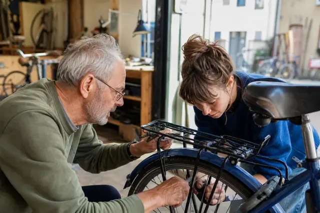 Vrijwilligers helpen samen een fiets repareren